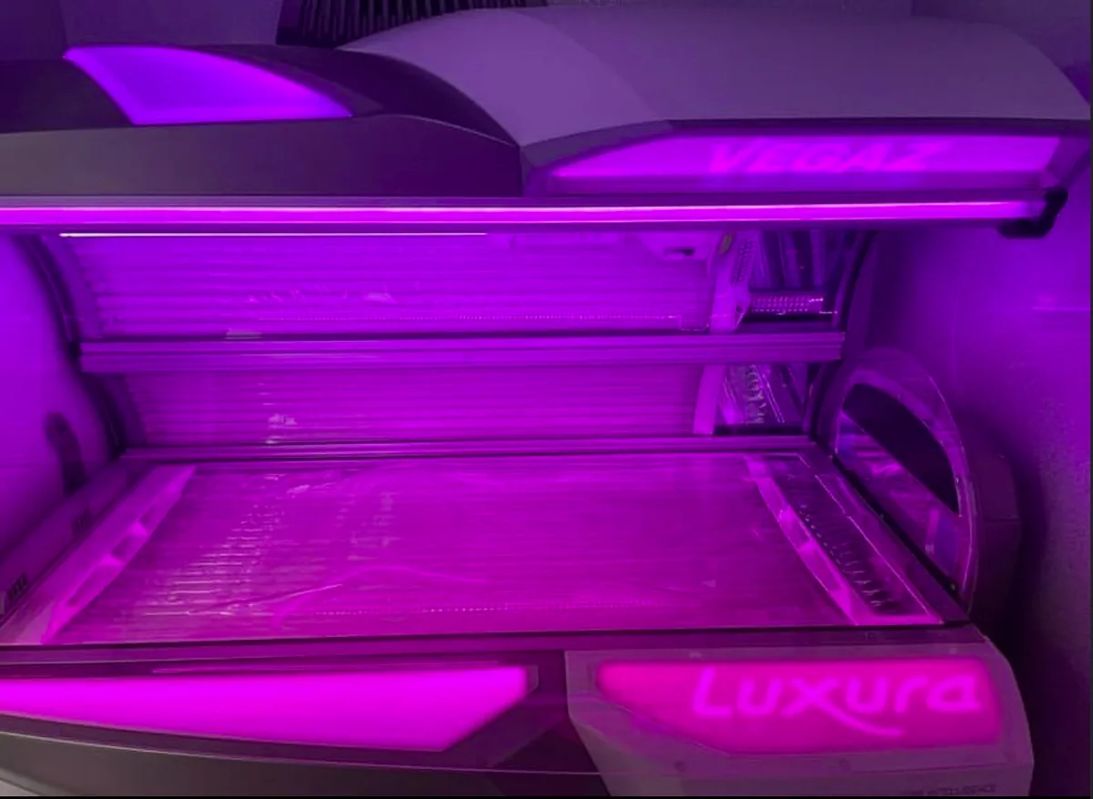 Luxura lay-down sunbed in deep magenta light